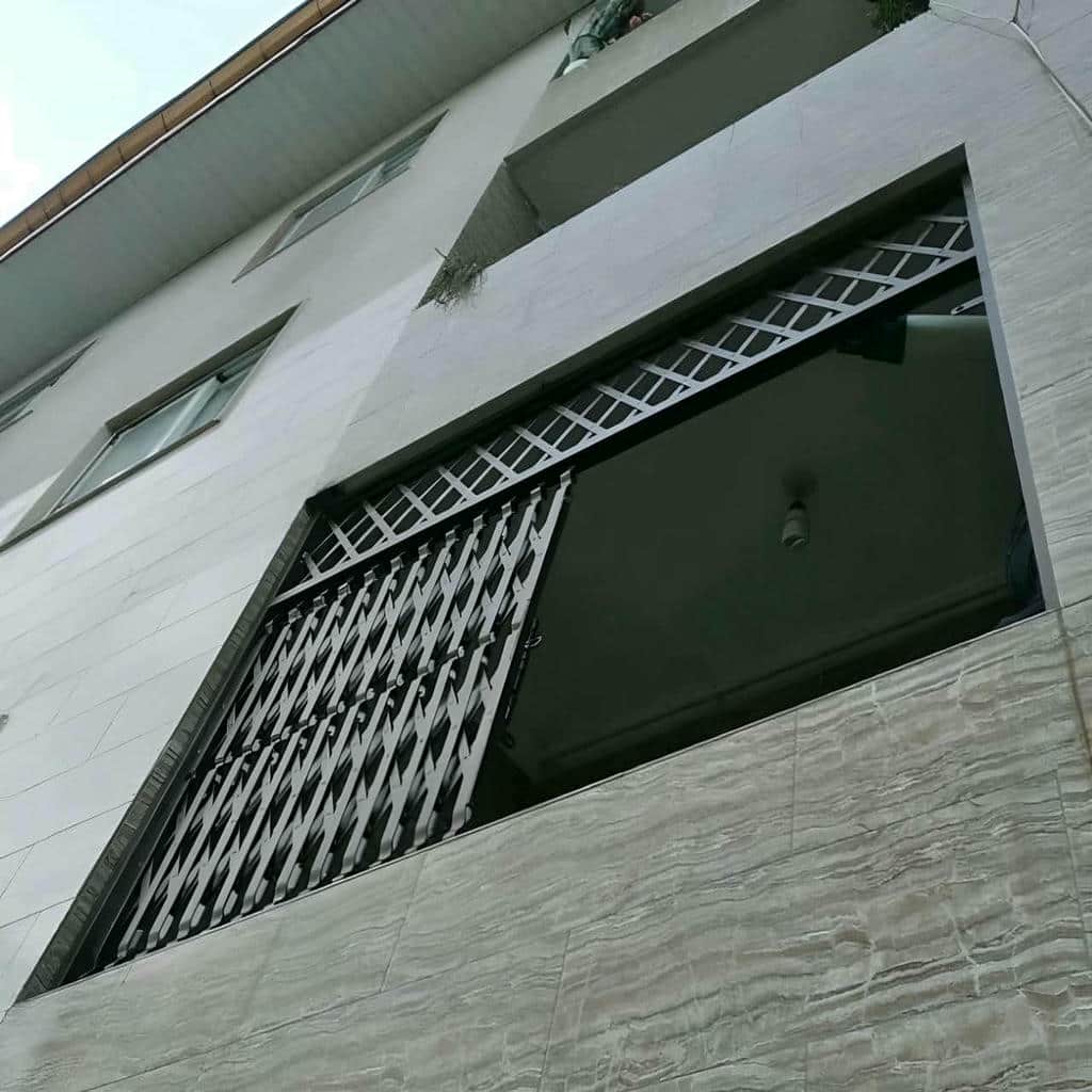 حفاظ درب آکاردئونی سفید روی چارچوب کج اردبیل