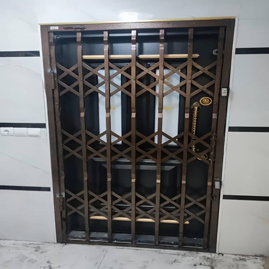 حفاظ درب آکاردئونی طوسی کنار ایوان باران‌گیر استان گیلان