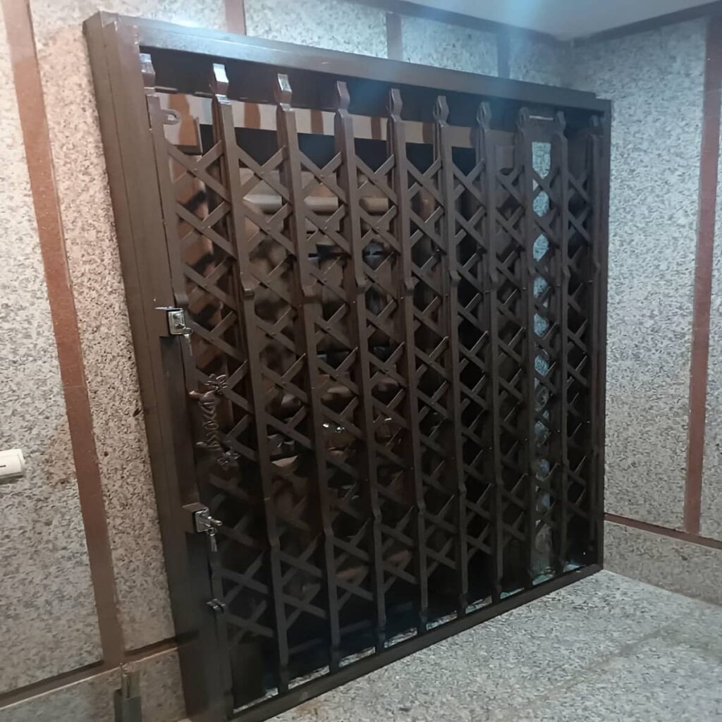 حفاظ درب آکاردئونی مشکی در ورودی آفتاب‌گیر استان کرمان