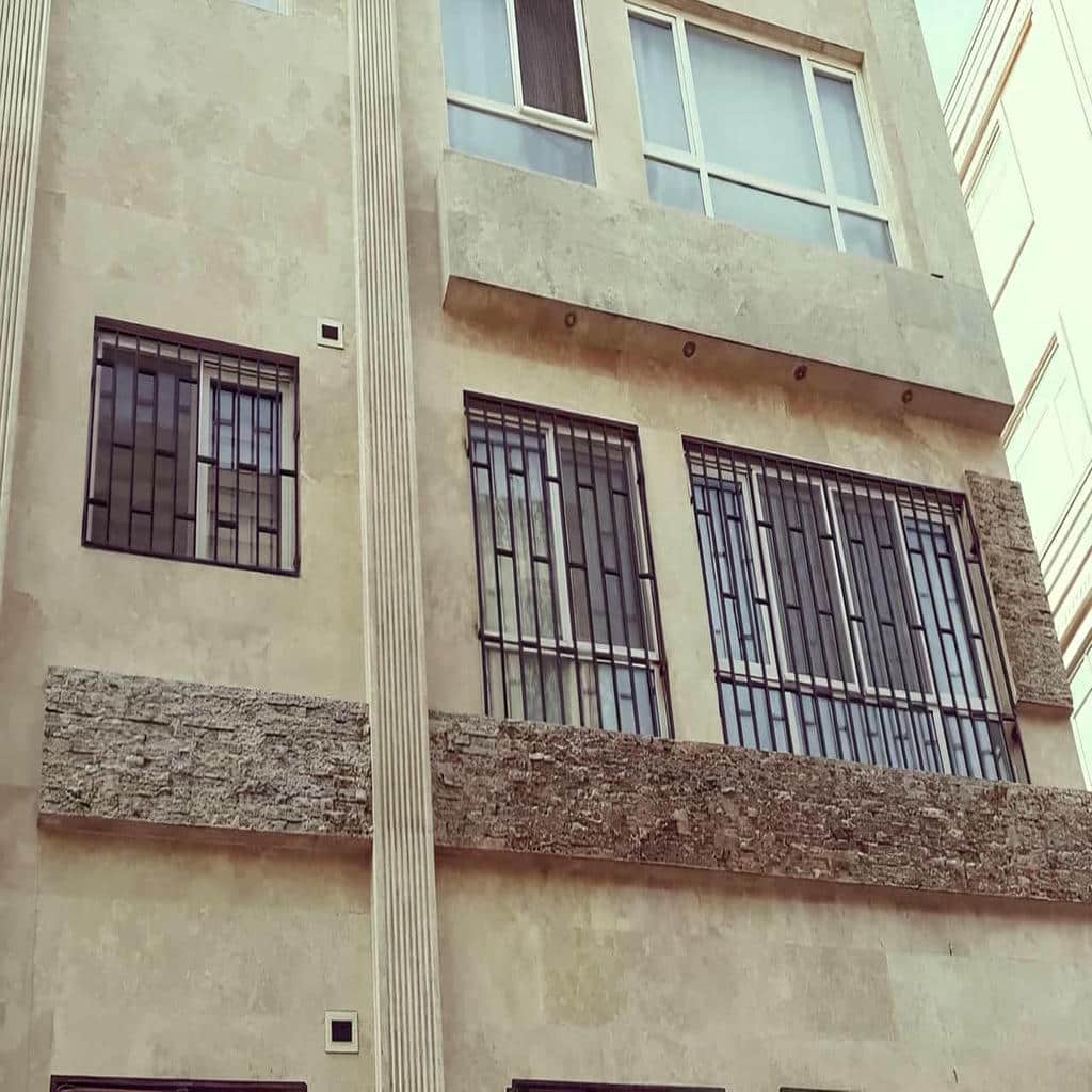 حفاظ پنجره هندسی روی نمای آجری آپارتمان حفاظ پنجره هندسی روی نمای آجری آپارتمان