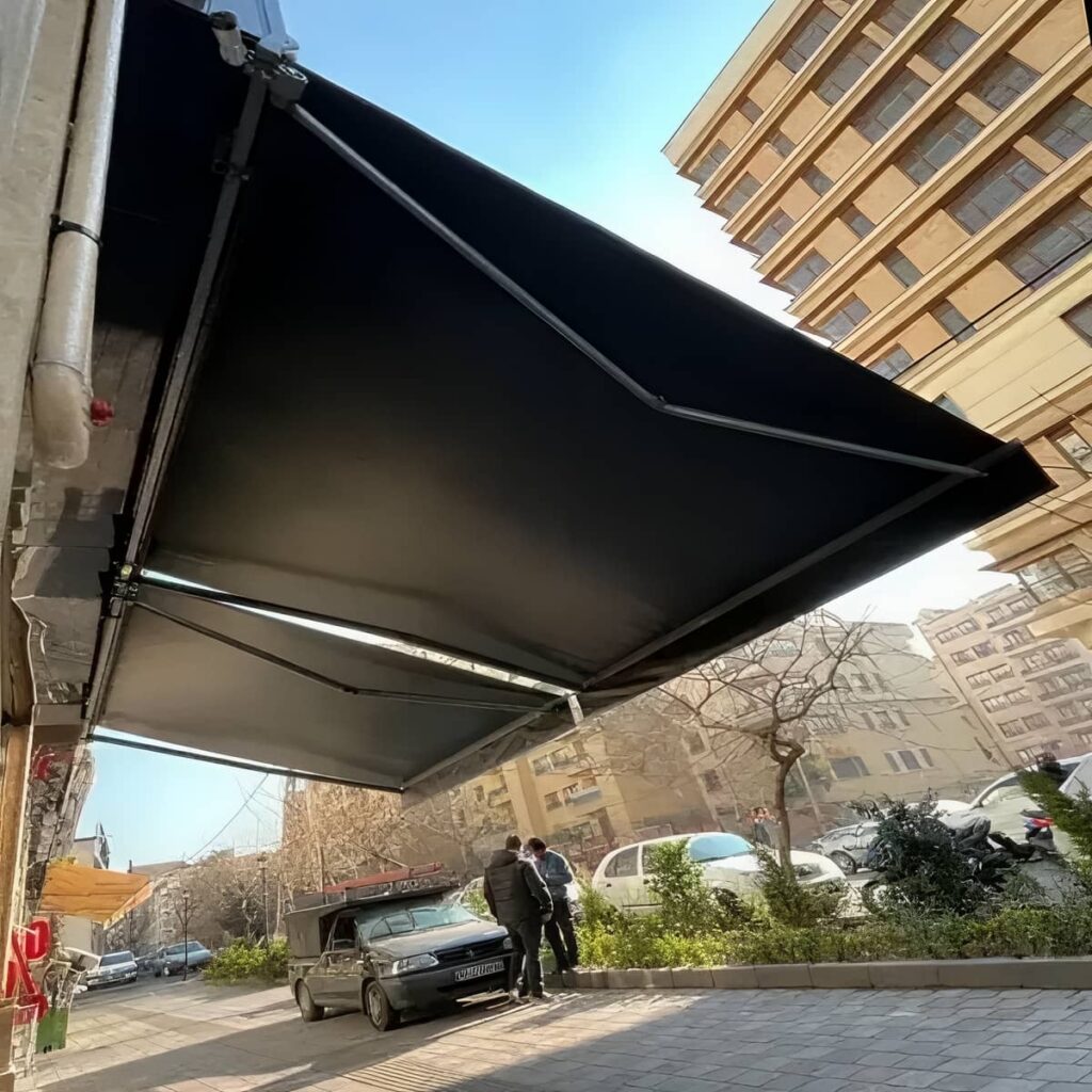 سایبان برقی بازشده روی تراس کوچک با جان پناه شیشه ای