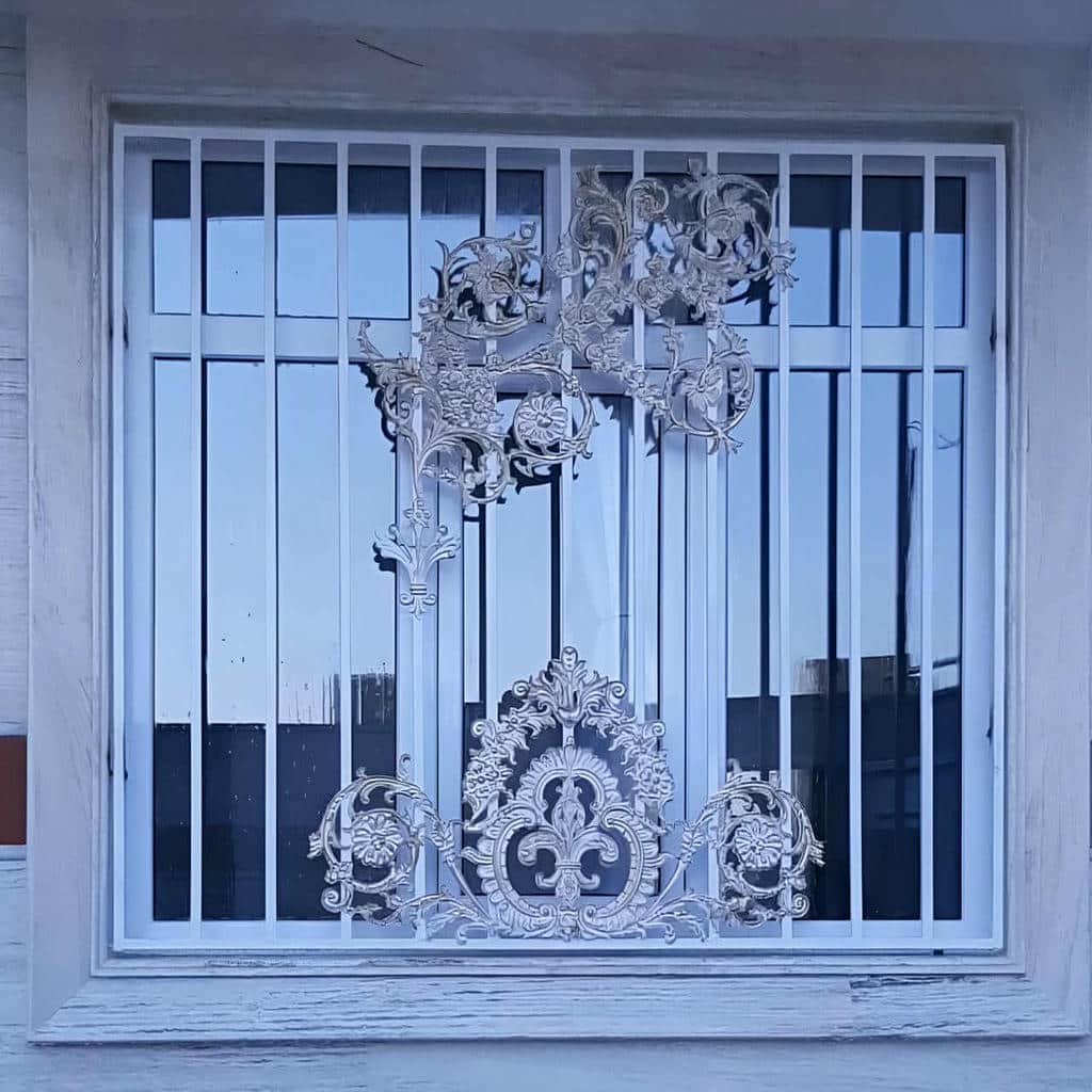 محافظ پنجره سفید روی نمای سیمانی حیاط