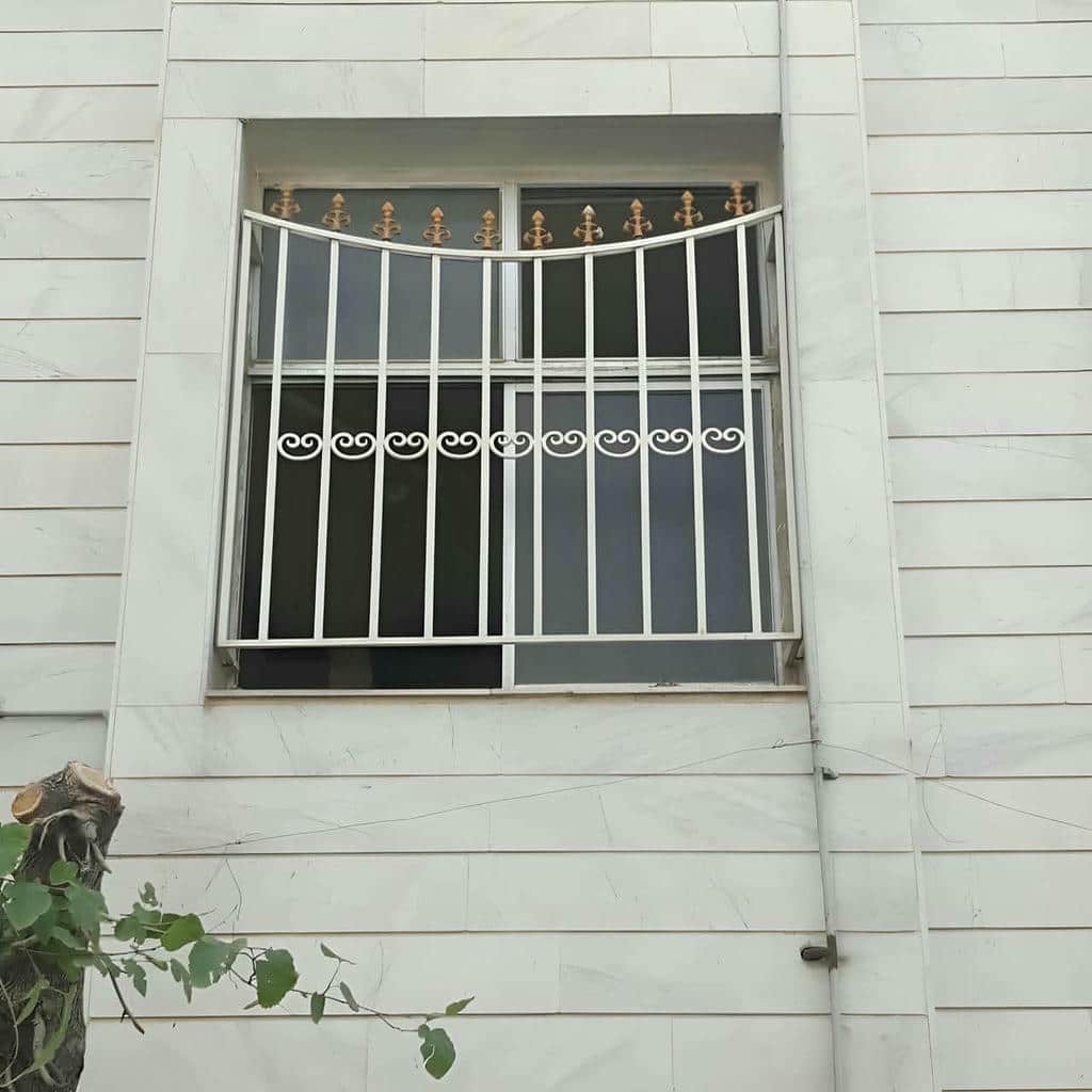 نرده ساده عمودی مقابل پنجره ساختمان باغی