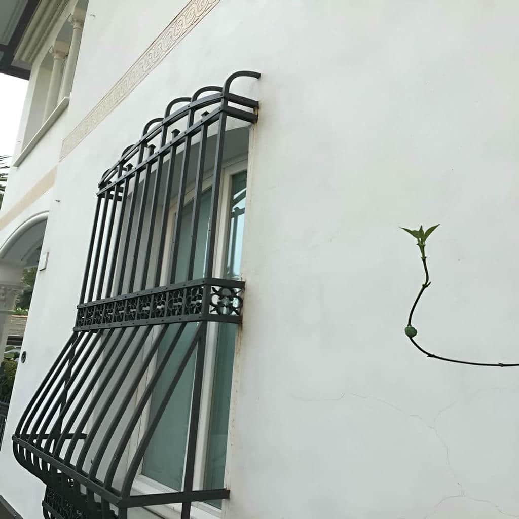 نرده پنجره با پوشش خاکستری روی نمای سیمانی نرده پنجره با پوشش خاکستری روی نمای سیمانی